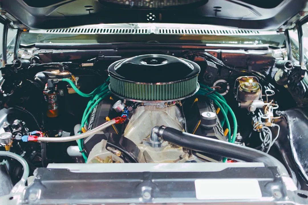 Mechanic performing a pre-purchase inspection on a large SUV engine bay in a Dubai workshop